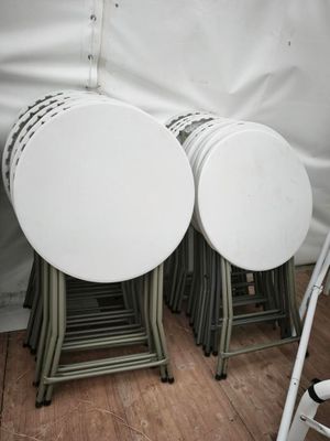 quatre tables blanches et quatre chaises sous une tente