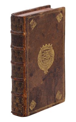 un vieux livre orné d'un emblème doré sur la couverture