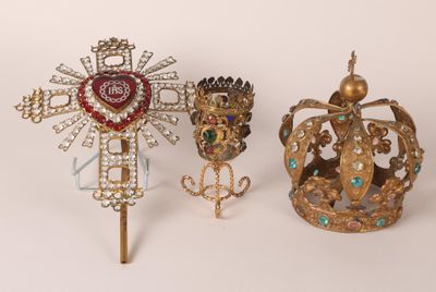 deux couronnes et une croix sont posées sur une surface blanche