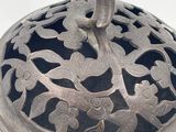a silver plate with a bird on it on a white surface