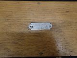 a small metal tag on a wooden table