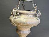 an old metal hanging light fixture with a bell on top of it