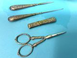 three pairs of scissors and a pair of scissors on a blue surface