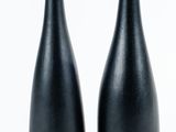 deux vases noirs posés sur une surface blanche