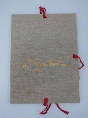 un gros plan d'un livre avec une inscription dorée sur une surface blanche