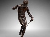 une image représentant une statue en bronze d'un homme tenant une raquette de tennis