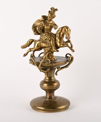 brass figurine of a man on a horse on a pedestal
