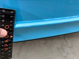 someone is measuring the height of a blue car with a ruler