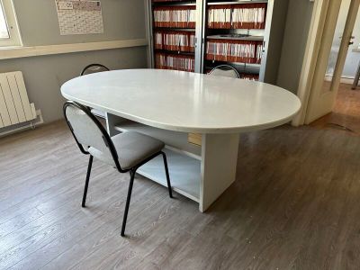 a table and chairs in a room with bookshelves