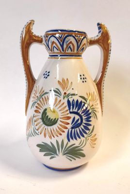 un vase blanc orné d'un motif bleu et jaune