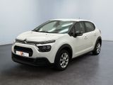 Une Citroën blanche est garée dans une pièce blanche