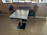 a table and two chairs in a small room