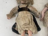 two dolls laying next to each other on a white surface