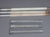 four pencils and two erases are lined up on a table
