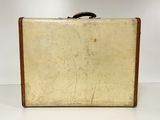 an old suitcase sitting on a table with a white wall behind it