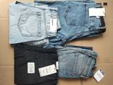 Trois paires de jeans pour homme sont disposées sur une boîte en carton