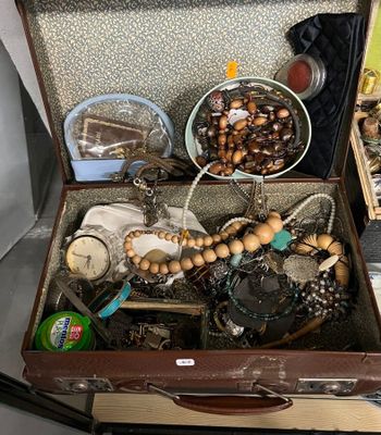 une valise remplie de bijoux et d'autres objets posée sur une table