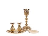 une assiette en argent avec une coupe en or et une assiette en argent sur laquelle repose une pièce de monnaie