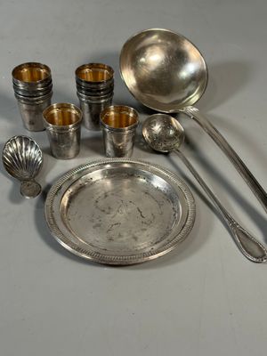 un plateau en argent sur lequel sont disposées des cuillères, des tasses et des cuillères