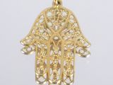 une image d'un pendentif en forme de main de Hamsa en or, avec des motifs en filigrane, filigrane, filigrane, fili
