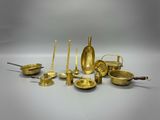 un ensemble d'objets en laiton, comprenant notamment des bougies, des cuillères et d'autres objets