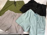 quatre paires de shorts de bain pour homme posées sur une table