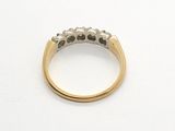 a close up of a gold ring with diamonds on a white surface