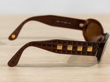 sunglasses on a wooden table with a white wall in the background