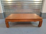 une table basse en bois avec une porte en métal en arrière-plan