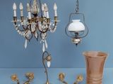 a chandelier that is next to a vase on a table