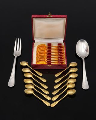 a box with a set of silverware on a black surface
