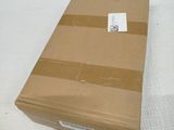 a cardboard box sitting on a bed with a tag on it
