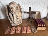 une statue d'ange à côté d'un crucifix et d'une boîte de bougies