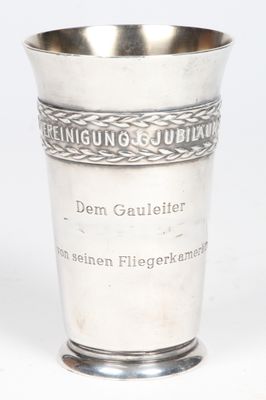 une coupe en argent portant une inscription, posée sur une table