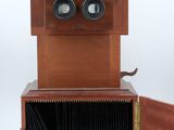 an old wooden camera with two lenses and a wooden case
