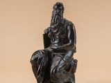 l'image d'une statue d'un homme assis sur une chaise