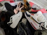 many pairs of shoes that are sitting on a bed