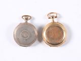 two gold and silver pocket watches on a white surface