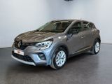 a grey car parked in a showroom with white walls