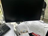 a computer monitor sitting on a desk with papers and a keyboard