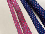 three ties with different designs are laying on a table