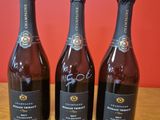 trois bouteilles de vin posées sur une table en bois