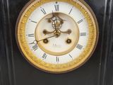 a black and gold clock with roman numerals on it