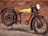 a old motorcycle that is parked in front of a brick wall