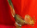 une image représentant un oiseau en verre doré sur fond rouge