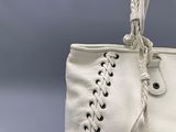 un sac à main blanc avec une anse tressée sur fond gris