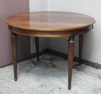 une table ronde avec un plateau en bois, placée dans un coin
