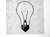 black and white drawing of a light bulb on a piece of paper