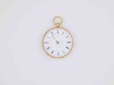 a close up of a gold pocket watch with roman numerals