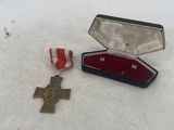 a small box with a medal and a red ribbon in it